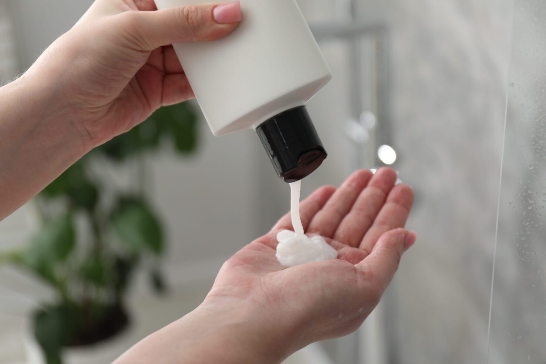 Woman pouring shampoo into hand